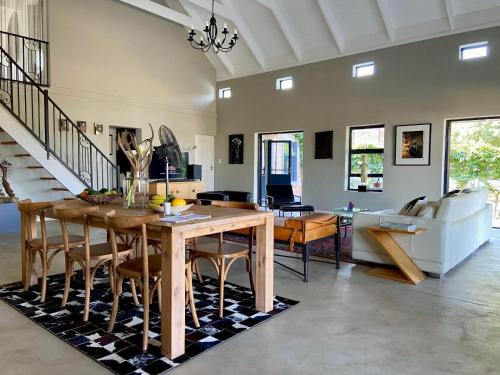 a living room with a wooden table and chairs at Julu Guest House in Riebeek-Kasteel