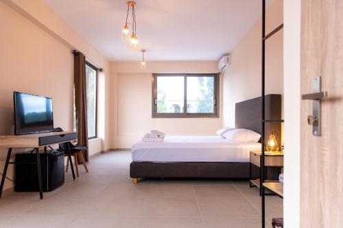 a bedroom with a bed and a television at Mini Suites Free shuttle from and to Athen's Airport in Spáta