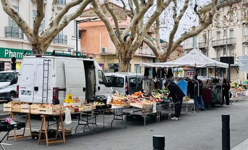 a market with fruits and vegetables on tables in a street at Appartement T3 67m² in Perpignan