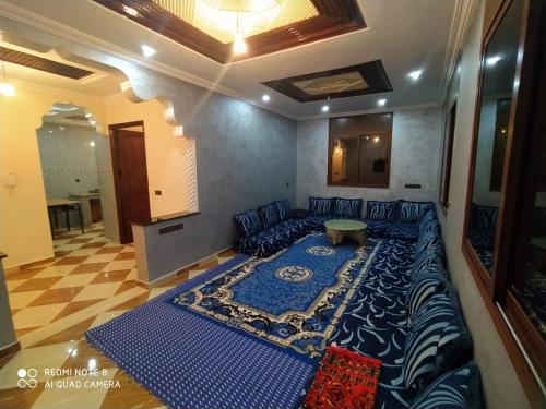 1 cama grande en la sala de estar con manta azul en Maison Lahoucine, en Sidi Ifni