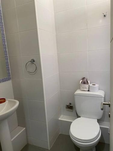 a white bathroom with a toilet and a sink at Departamento moderno, vista al mar y estacionamiento incluido in Antofagasta