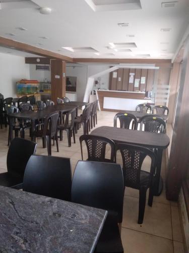 a dining room with tables and chairs in a restaurant at OOTY ACHY APARTMENT COTTAGE in Ooty