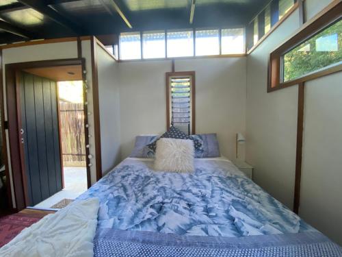 a bed in a small room with a window at Sleepy Hollow adorable peaceful guesthouse. in Gnarabup