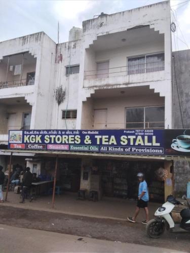 a building with a sign that reads kick stores and tea stall at OOTY ACHY APARTMENT COTTAGE in Ooty