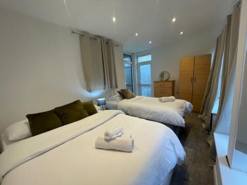 a bedroom with two beds with towels on them at Park View Homestay in Barking