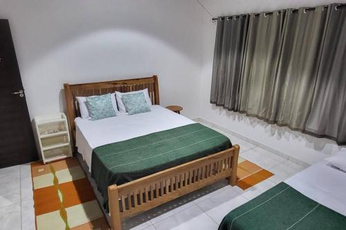 a bedroom with a bed and two windows with curtains at Solar Serra Negra Bezerros - PE in Bezerros
