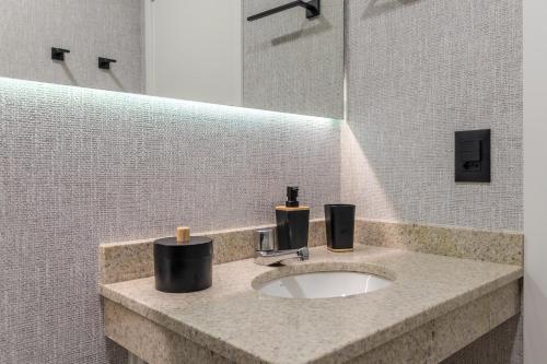 a bathroom sink with two soap dispensers on it at Akile Landing Congonhas in Sao Paulo