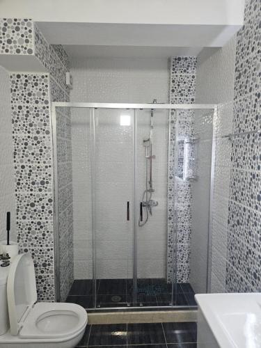 a bathroom with a shower with a toilet and a sink at Appartamento Saranda in Sarandë