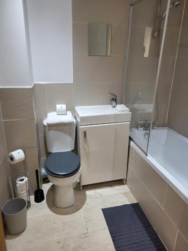 a bathroom with a toilet and a sink and a tub at Imperial House "Serviced Apartments" in Margate