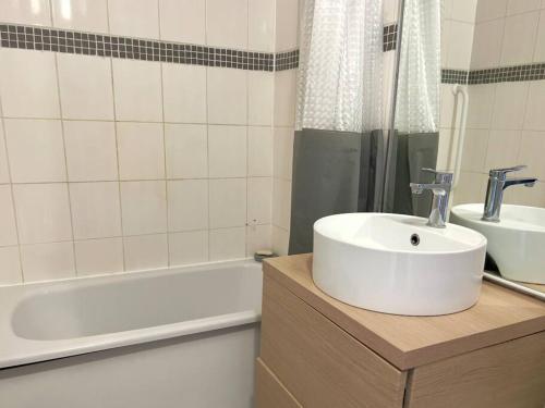 y baño con lavabo y bañera. en Proche Paris - Parking - 2 Chambres - 5 personnes, en Fresnes