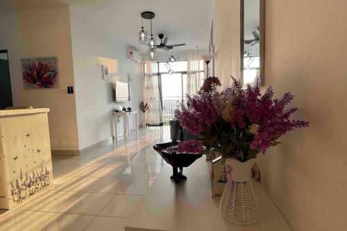 a living room with a vase with flowers in it at Benoni 3 Bedroom - Farah Biz Empire Homestay in Papar