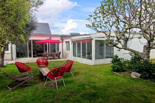 - une cour avec des chaises, une table et un parasol dans l'établissement Maison plain-pied entièrement neuve / 4 chambres, à Saint-Cast-le-Guildo