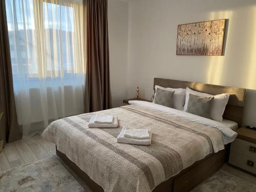 1 dormitorio con 1 cama grande y 2 toallas. en Tei Residence, en Piatra Neamţ