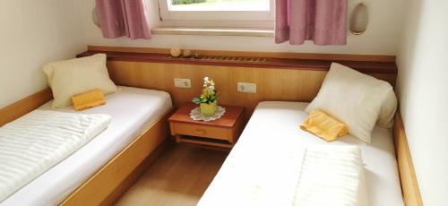 カプルーンにあるAppartements Mary inklusive Tauern-Spa Kaprunのベッド2台と窓が備わる小さな客室です。