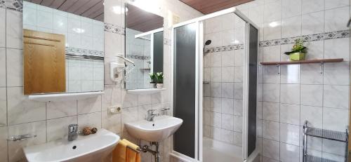 bagno bianco con lavandino e specchio di Appartements Mary inklusive Tauern-Spa Kaprun a Kaprun