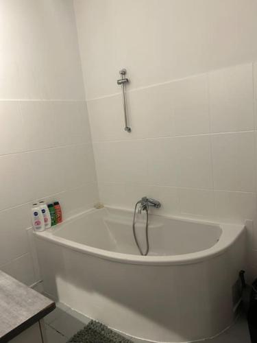 bañera blanca con grifo en el baño en Superbe appartement avec parking gratuit, en Vaulx-en-Velin