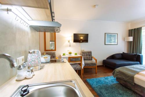 a kitchen with a sink and a living room at Apartment am Tannenweg in Badenweiler