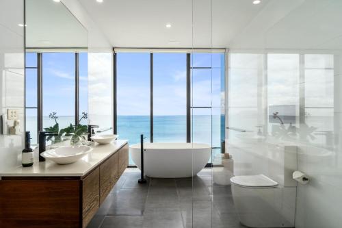 a bathroom with two sinks and a tub and a large window at Cape Wye in Wye River