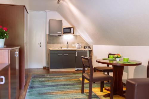 a kitchen with a table and chairs and a sink at Apartment am Tannenweg in Badenweiler