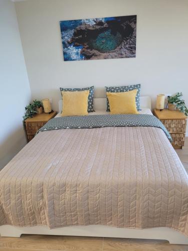 ein Schlafzimmer mit einem großen Bett mit gelben Kissen in der Unterkunft Cosy ocean view studio 2 in San Marcos