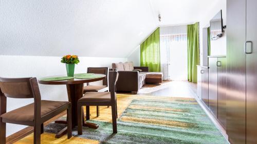 a living room with a table and chairs at Apartment am Tannenweg in Badenweiler
