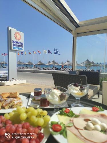 a table with plates of food on the beach at GOLDEN SUN Κokkoni Beach Hotel in Vrahati