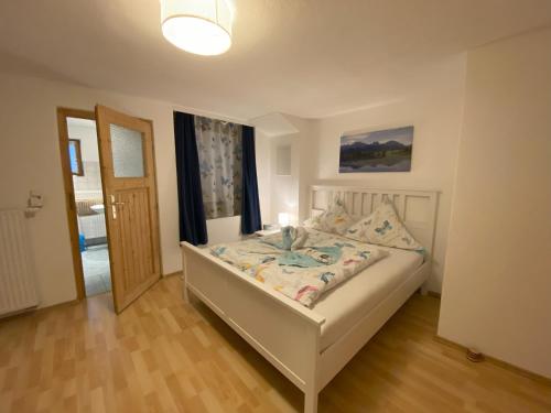 1 dormitorio con 1 cama con lámpara y puerta en Casa Fuessen, en Füssen