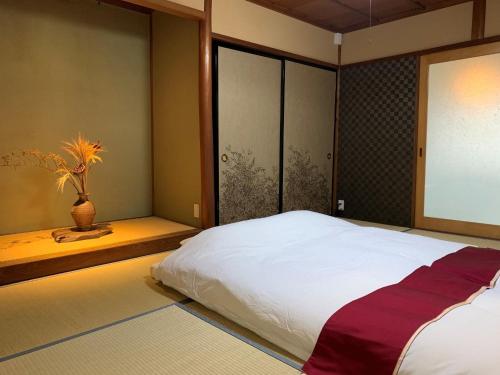 a bedroom with a large white bed and a window at Folksy House / Vacation STAY 64171 in Izumo