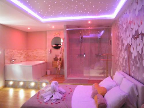 Studio Love Spa Baignoire XXL Port Vieux La Ciotat في لاسيوتا: غرفة نوم مع دش وسرير مع دمى عليه