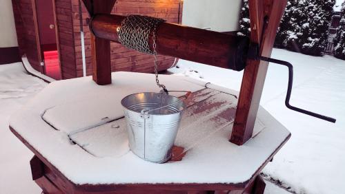 a bucket is being hooked up to a snow covered machine at Chwile w Starym Sączu, sauna i beczka in Stary Sącz