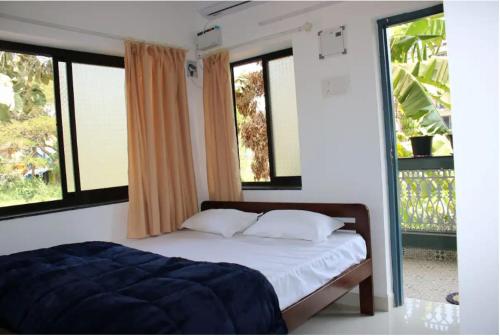 um quarto com uma cama e duas janelas em Hotel innovation inn em Baga