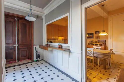eine Küche und ein Esszimmer mit einem Tisch und einer Theke in der Unterkunft Chambre spacieuse dans magnifique appartement XVII in Grenoble