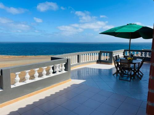a balcony with a table and an umbrella at Residencial Sol Point Art in Ponta do Sol