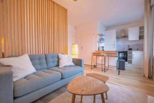 un salon avec un canapé bleu et une cuisine dans l'établissement Le Jéroboam, à Reims