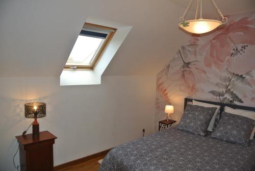 a bedroom with a bed and a window and a chandelier at Gîte Les Chênes in Villeneuve-les-Sablons