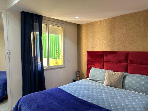 a bedroom with a bed with a red headboard and a window at Lovely city center flat near the old Medina in Casablanca