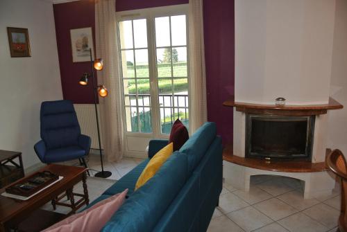 a living room with a blue couch and a fireplace at Gîte Les Chênes in Villeneuve-les-Sablons