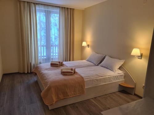 a bedroom with a bed with two towels on it at Forest Apartment/ Villa Park in Borovets