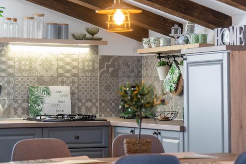 a kitchen with a stove and a table with chairs at Opg Pelejš in Pag