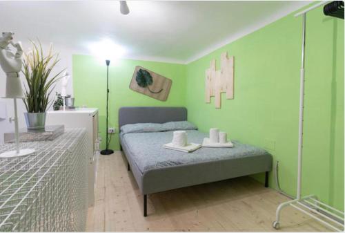 - une chambre avec des murs verts et un lit avec des chaussures dans l'établissement Little Loft 14 appartamento vicino il centro di Bari, à Bari