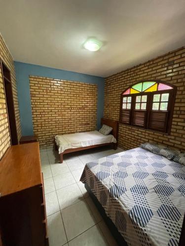 a bedroom with two beds and stained glass windows at Casa na serra de mulungu in Mulungu