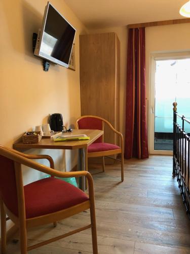 a room with a table and chairs and a television at Gästehaus Baldauf in Berwang