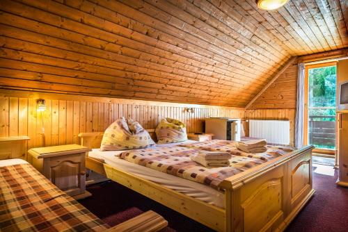ein Schlafzimmer mit einem großen Bett in einem Holzzimmer in der Unterkunft Chata Liptov in Liptovský Ján