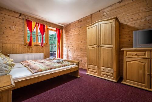 a bedroom with a bed and a tv on a cabinet at Chata Liptov in Liptovský Ján