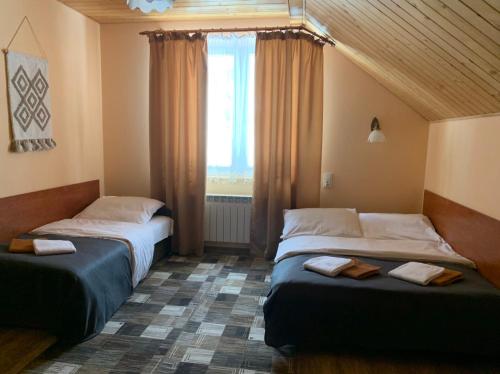 2 camas en una habitación con ventana en Alpina en Krynica Zdrój