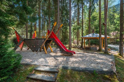 a playground with a slide and a table in the woods at Chata Liptov in Liptovský Ján