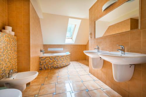 ein Badezimmer mit zwei Waschbecken und einer Badewanne in der Unterkunft Chata Liptov in Liptovský Ján