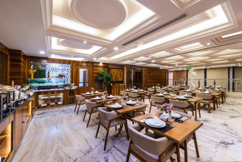 a restaurant with wooden tables and chairs and a bar at Crown Rose AlSahafa Hotel in Riyadh