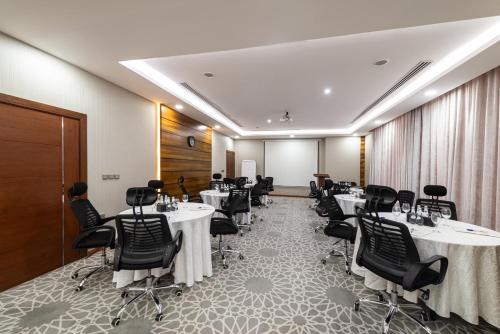 a conference room with tables and chairs in it at Crown Rose Al Sahafa Hotel in Riyadh