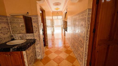 een badkamer met een wastafel en een betegelde muur bij dar haut de gamme Et à un prix imaginaire Hostcom in Oujda